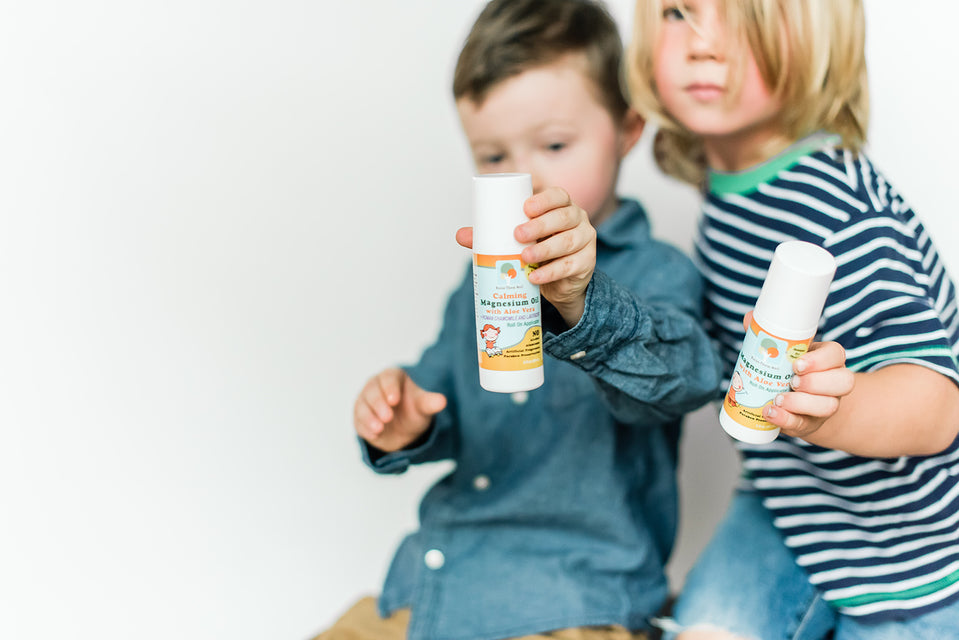 two young boys bringing their Raise Them Well kid-safe roll-on calming magnesium oil for mom to apply