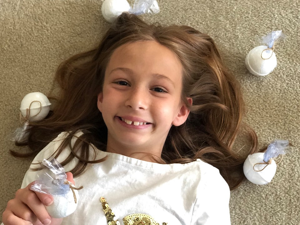 young girl with Raise Them Well's kid-safe calming magnesium bath bombs