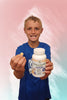 Child holding a bottle and a chewable supplement against a colorful background