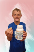 Child holding a bottle and a chewable supplement against a colorful background